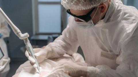 Chirurg soustředěně provádí laserový zákrok v operačním sále, ilustrace výběru kliniky na oči
