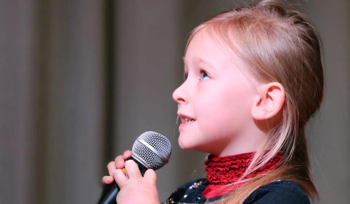 Dívka zpívá do mikrofonu na pódiu · Foto: Pixabay / Pexels Holčička recituje či zpívá do mikrofonu, ilustrace k učení básničky zpaměti