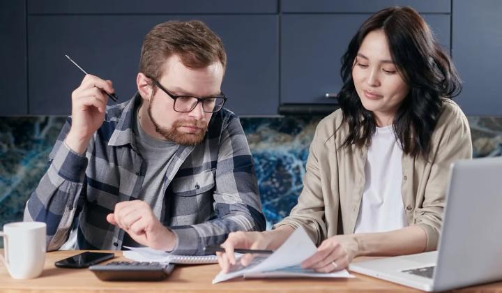 Pár společně kontroluje účty u stolu · Foto: Mikhail Nilov / Pexels Pár společně počítá a kontroluje domácí účty u stolu s notebookem
