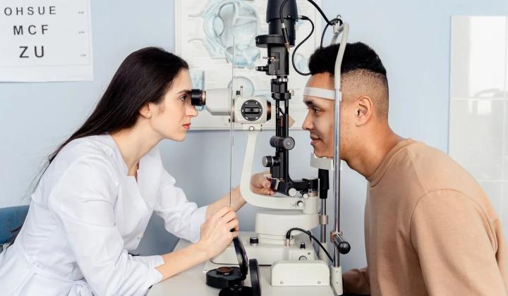 Oční lékařka vyšetřuje pacienta na štěrbinové lampě před laserovou operací očí