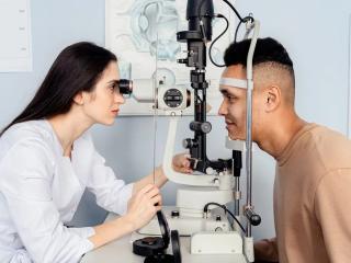 Oční lékařka vyšetřuje pacienta na štěrbinové lampě před laserovou operací očí