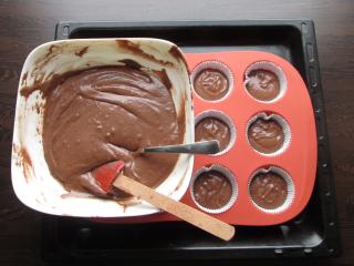 tmavé těsto ve formičkách rozdělení tmavého těsta do formiček na muffiny